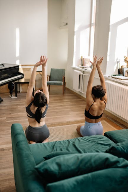 Woman performing a gentle yoga stretch in a sunlit living room.